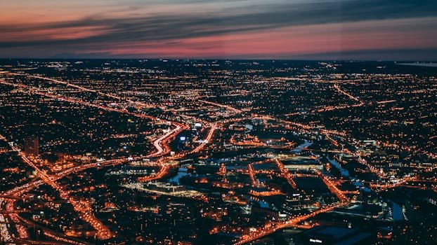 Captivating aerial cityscape of Chicago with illuminated streets and a vibrant dusk sky.